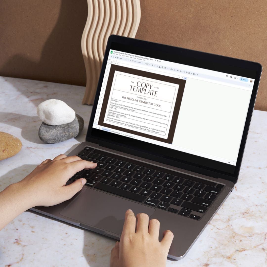 A person uses a laptop displaying a document titled "COPY TEMPLATE" on a marble surface, surrounded by decorative objects—an inspiring setting for brainstorming elements of a homepage.