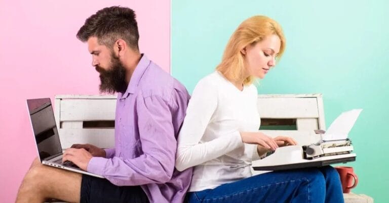 A man using a laptop for content writing and a woman using a typewriter for copywriting sit back-to-back against a pastel pink and green wall.
