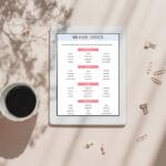 Tablet displaying a brand voice chart next to a cup of coffee and scattered paper clips on a beige surface with tree shadows.