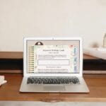 A laptop on a wooden desk displays a webpage titled "Keyword Strategy Goals." Nearby are a notebook, pen, and decorative items.