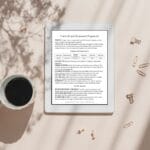 A tablet displaying a document titled "Content and Keyword Alignment" lies on a pink surface next to a cup of black coffee and scattered paper clips and binder clips.