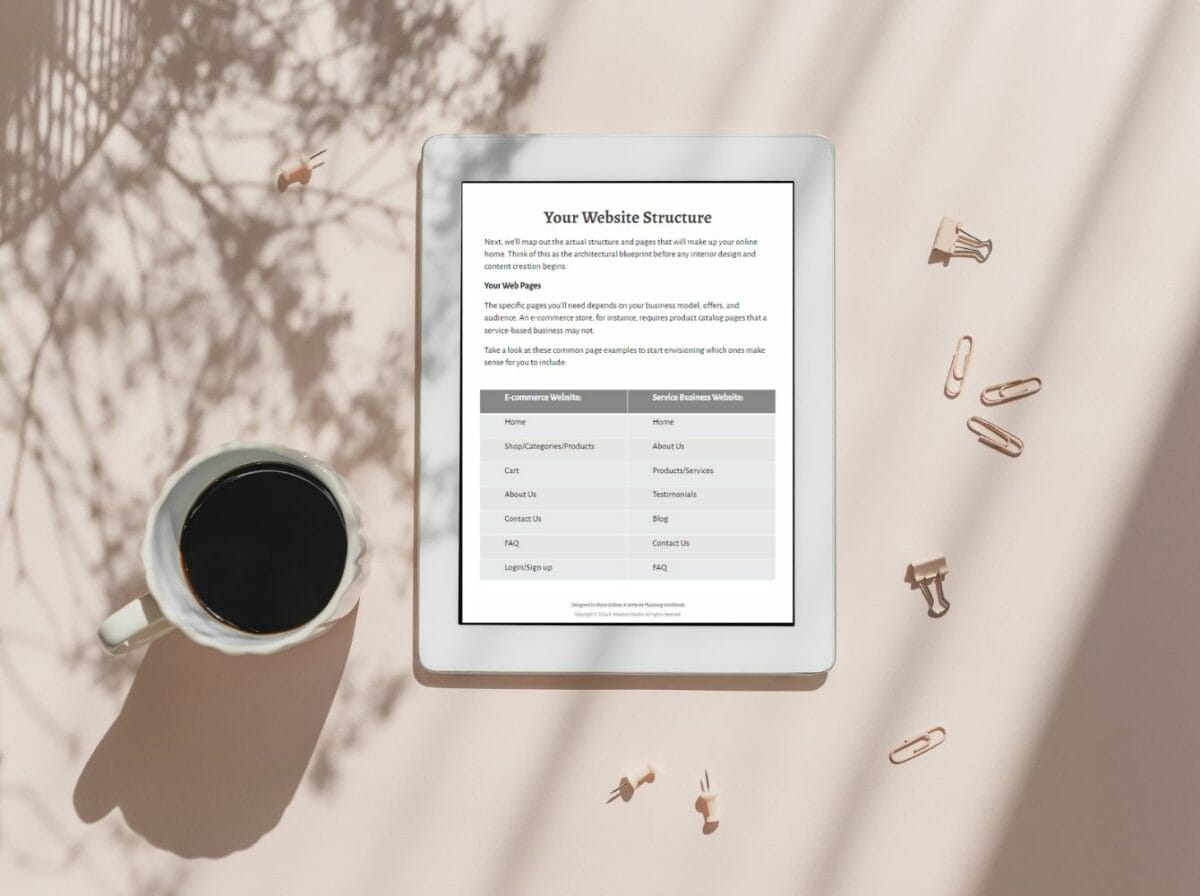 A tablet displaying a website structure document sits on a desk next to a cup of black coffee, paper clips, and cast shadows from plants.