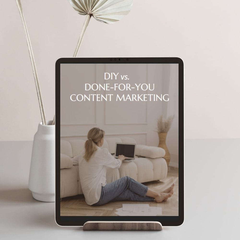 A tablet on a stand displays the text "DIY vs. Done-For-You Content Marketing" with an image of a woman working on a laptop while sitting on the floor, exploring free business resources.
