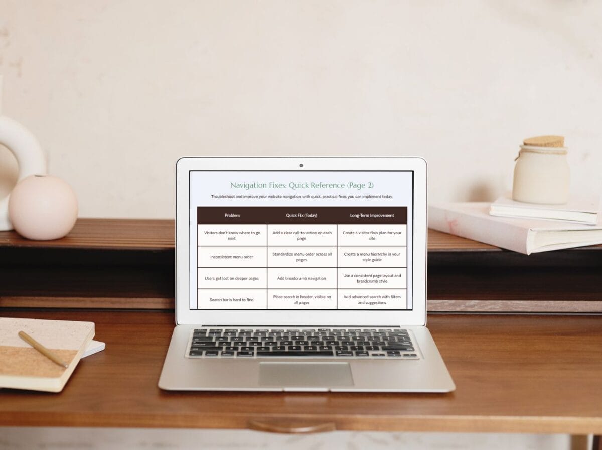 A laptop on a desk displays a troubleshooting reference chart. The desk also has notebooks, a pen, and decorative objects in the background.